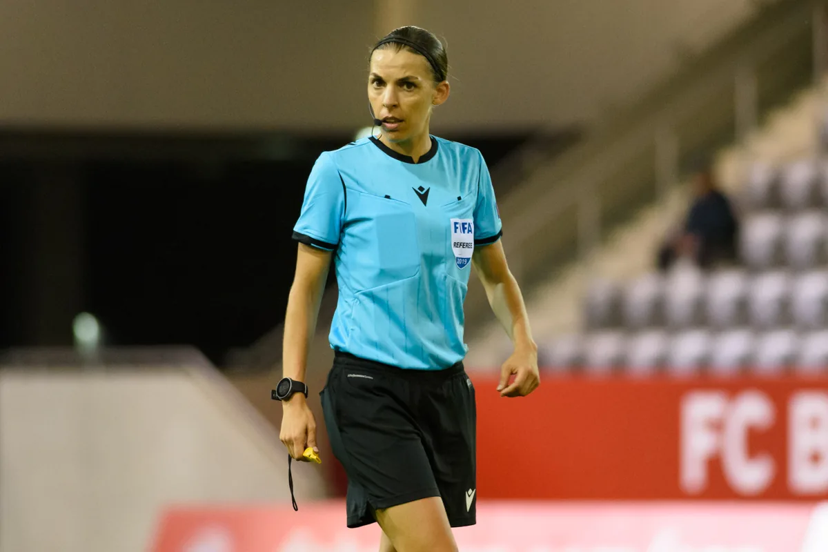 L’arbitre Stéphanie Frappart en tenue bleue sur un terrain de football.