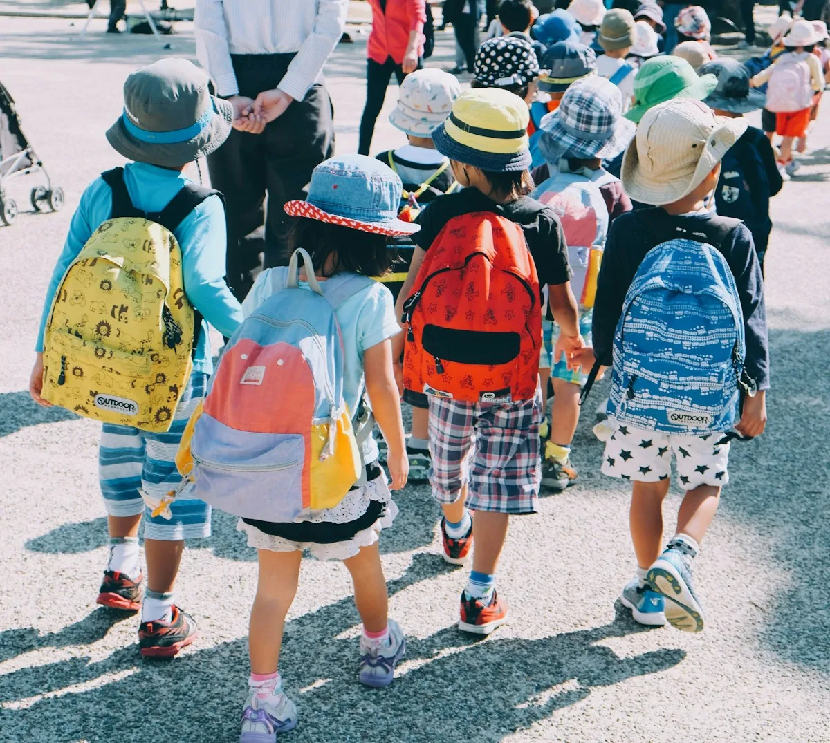 Des enfants portant un sac à dos marchent ensemble sur un chemin.
