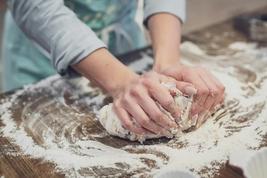Une personne travaille une pâte à la main.